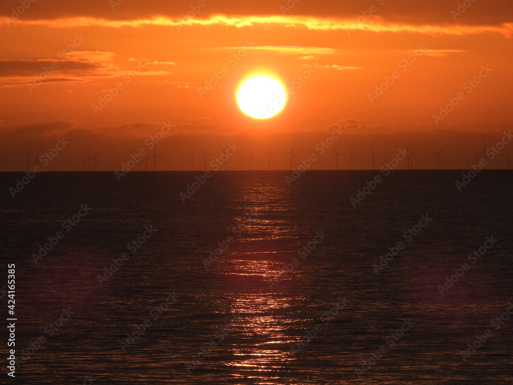 Round sun at sunrise at sea