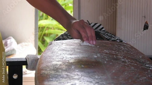 Planche de Surf entrain d'être polie à la cire 