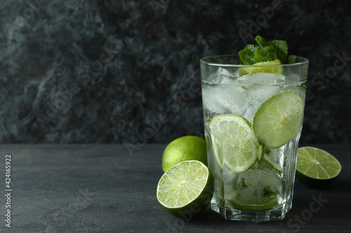 Glass of mojito cocktail and ingredient on dark wooden table