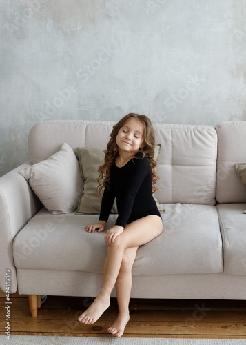 girl in a black swimsuit sitting on the couch
