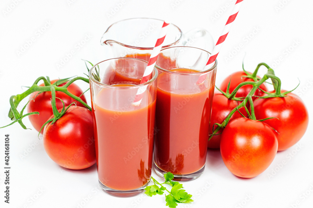 Fresh natural organic tomato juice in the glasses with paper straws and tomatoes on white background. Fresh natural organic tomato juice in the glasses with paper straws and tomatoes on white background.