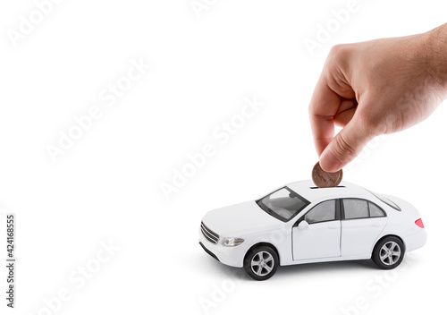 Putting coin into the car coin bank on white background
