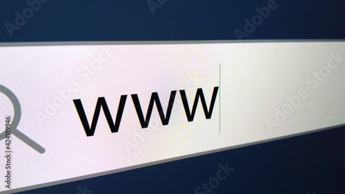 WWW written in search bar with cursor, computer monitor, close-up with camera zoom effect