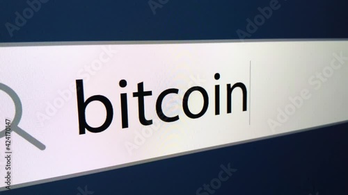 Bitcoin written in search bar with cursor, computer monitor, close-up with zoom effect