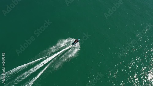 Jet ski fast movement on water aerial view. Diagonal movement of water scooter shooting camera drone. photo