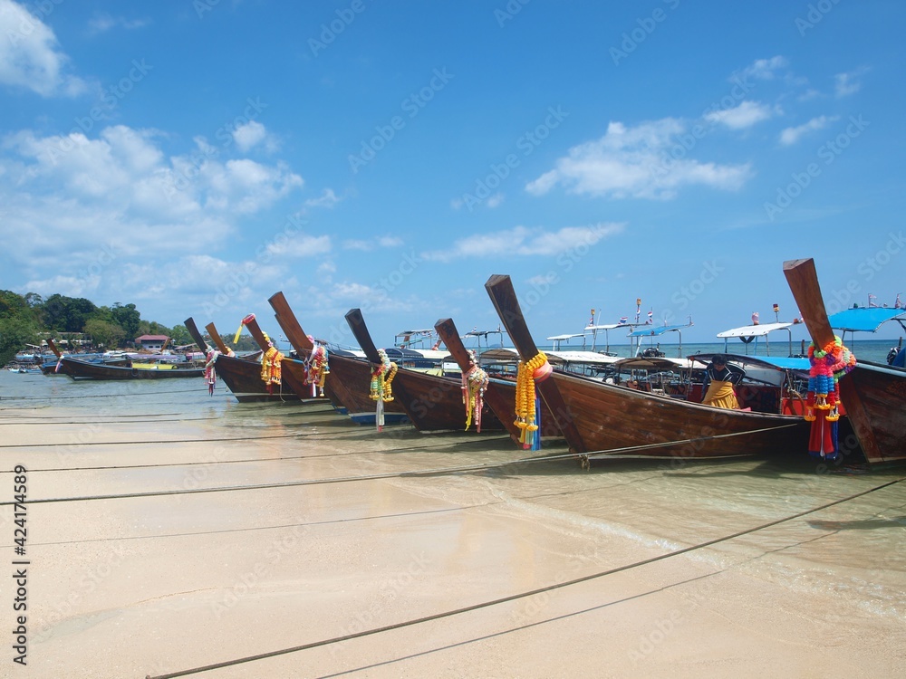 Thailand view. Longtail boats are on the shore. Sandy coast. Blue sky with clouds. Tour tourism to tropical island. Phi Phi, Phuket, Samui. Thai resort. Picture for advertising tourist service, trip. 