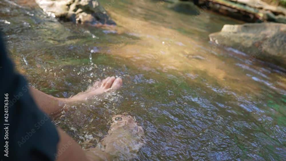 close up barefoot soaking in the waterfall canal river, resting during hiking on the weekend, freshness from nature, natural resources, swinging legs to splash the stream water, sitting on the edge close up barefoot soaking in the waterfall canal river, resting during hiking on the weekend, freshness from nature, natural resources, swinging legs to splash the stream water, sitting on the edge