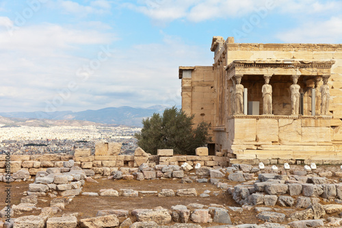 Greece. Acropolis of Athens. View of the famous porch with six magnificent statues of caryatids supporting the architrave of Erechtheion against backdrop of city of Athens. Summer travel 