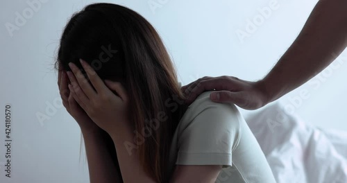 Psychologist touches a depressed Asian woman for encouragement.