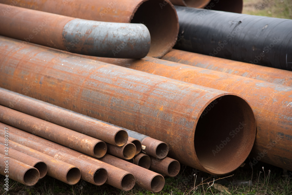 Construction gas pipes are stored outdoors. Pipe warehouse. Rusty. Different diameters.