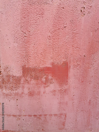 old pink shabby metal wall painted unevenly in several layers