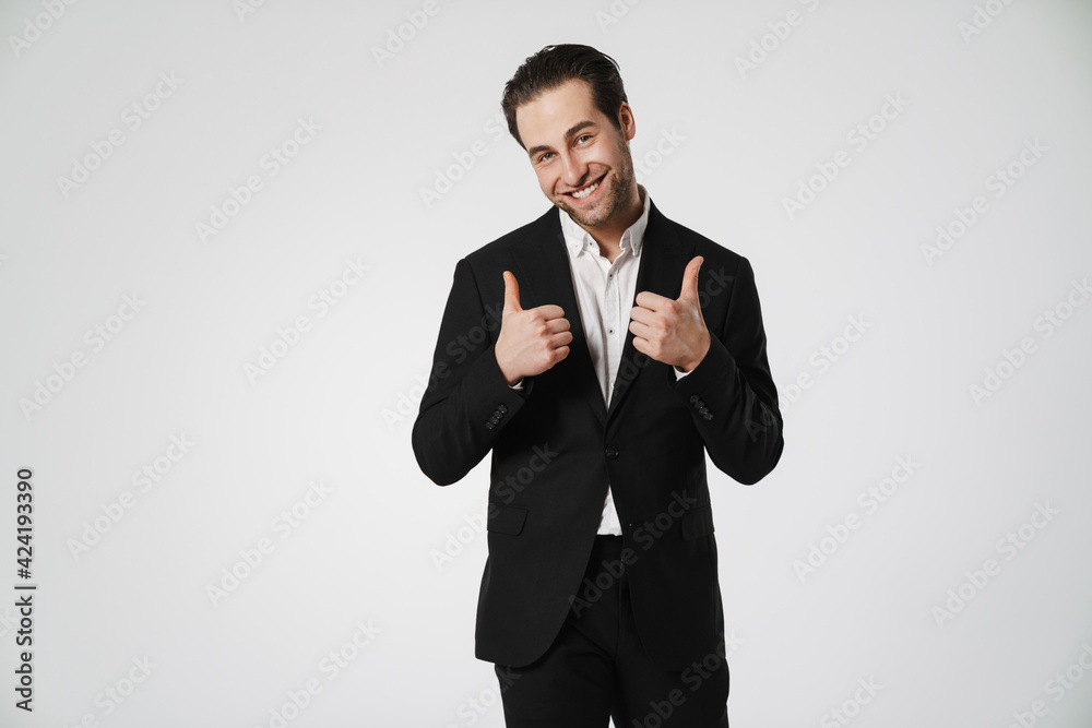 Unshaven brunette man in jacket smiling and showing thumbs up Unshaven brunette man in jacket smiling and showing thumbs up