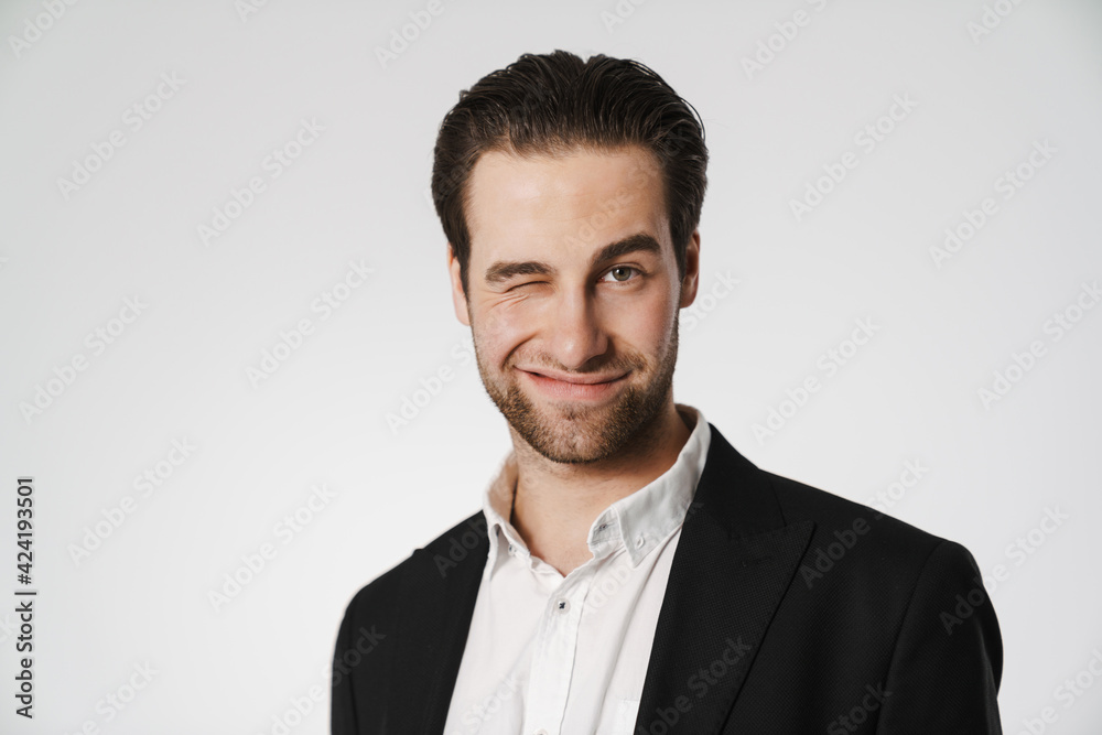 Unshaven brunette man in jacket smiling and winking at camera Unshaven brunette man in jacket smiling and winking at camera
