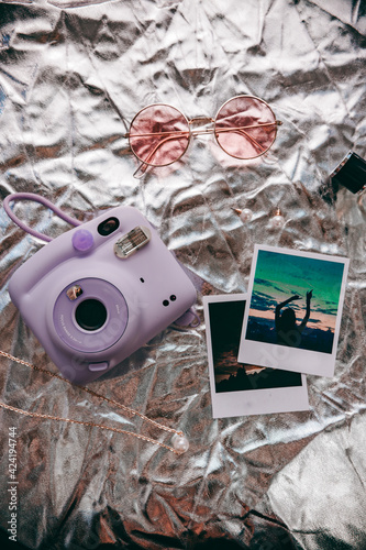purple polaroid on a silver background, rose-colored glasses and photos