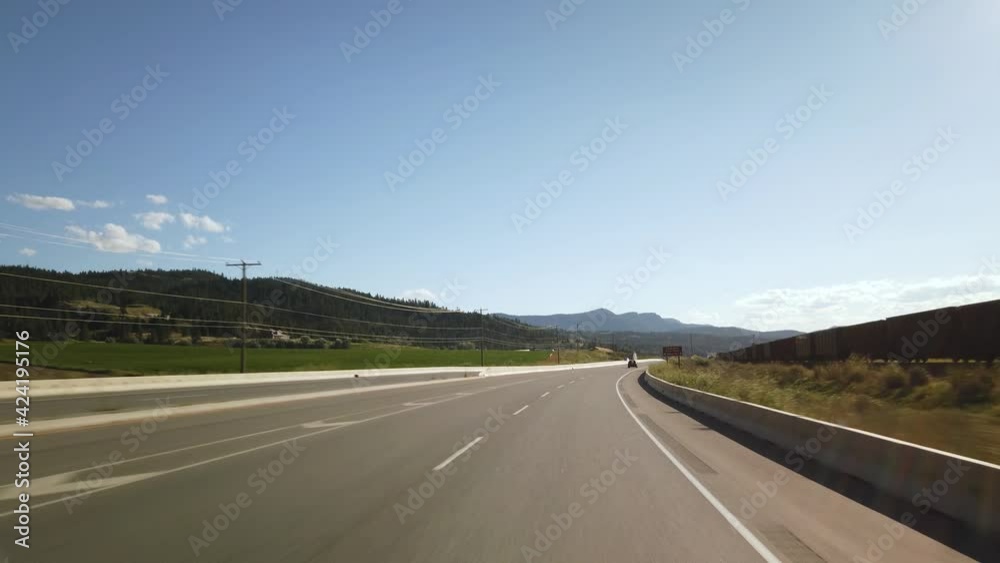 BC, CANADA- JULY 2019: Smooth & steady Driving on British Columbia highway during a sunny day next to farms and train track BC, CANADA- JULY 2019: Smooth & steady Driving on British Columbia highway during a sunny day next to farms and train track
