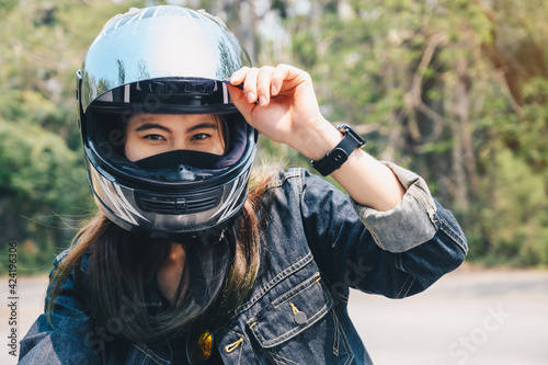 Obraz na plátne Young Asian woman wearing a motorcycle helmet before riding