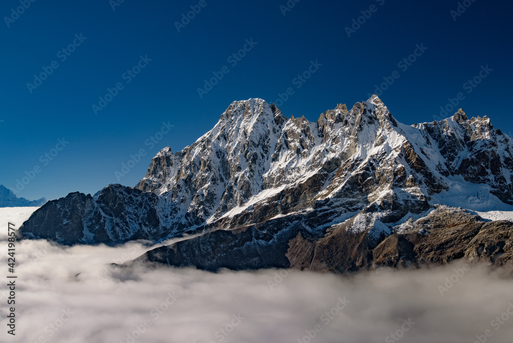 Snow mountains of Himalayas above clouds in Nepal