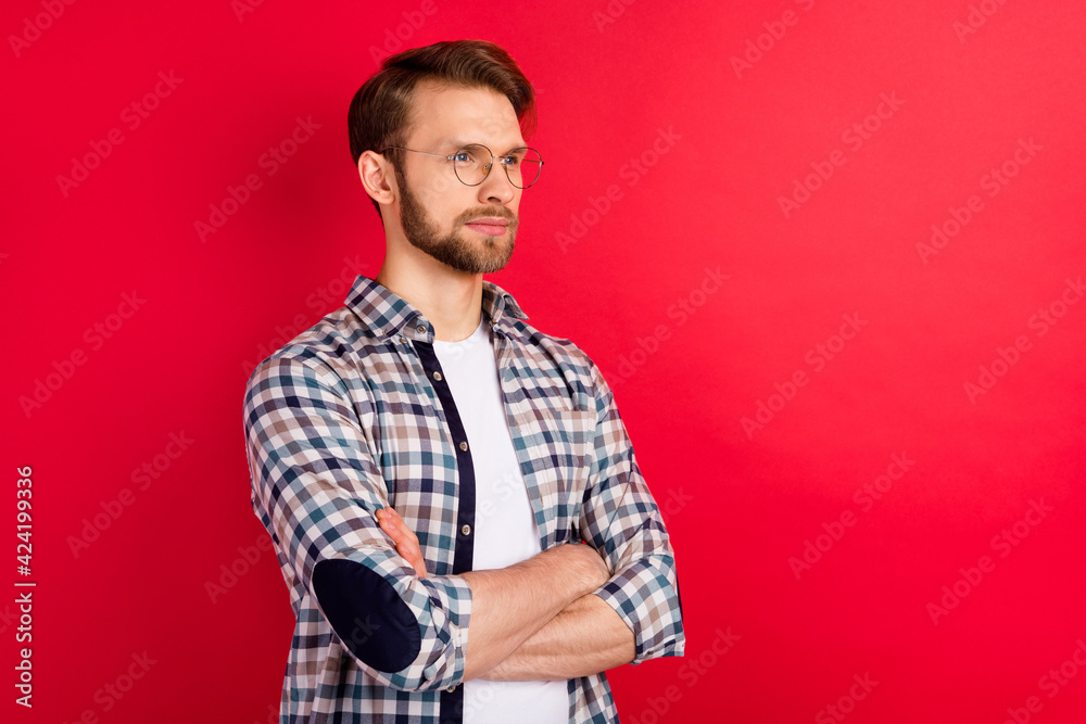Photo of adorable cute young guy wear checkered shirt glasses hands folded looking empty space isolated red color background