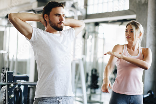 Healthy man and woman fitness exercising session in gym.