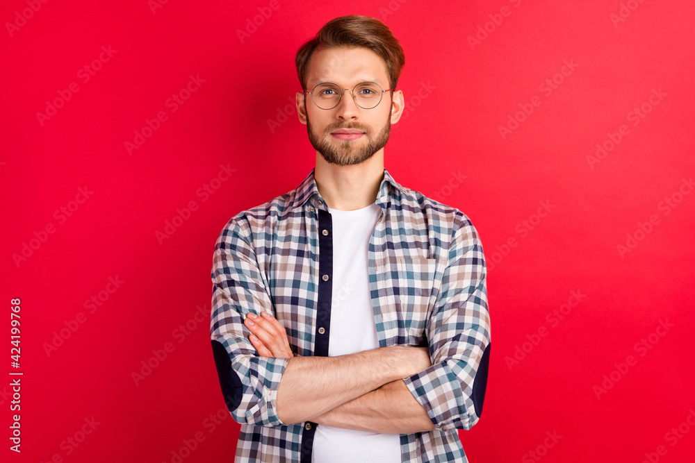 Photo of sweet confident young gentleman dressed plaid shirt spectacles arms crossed isolated red color background Photo of sweet confident young gentleman dressed plaid shirt spectacles arms crossed isolated red color background