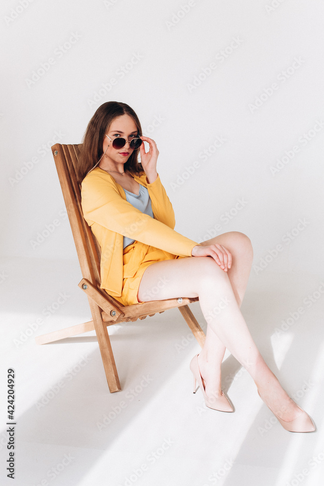 Sensualyoung woman in fashion glasses and yellow costume