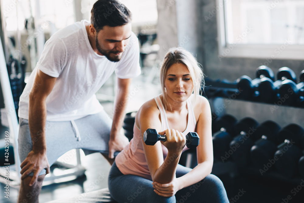 Sporty couple make weight lifting together in loft gym