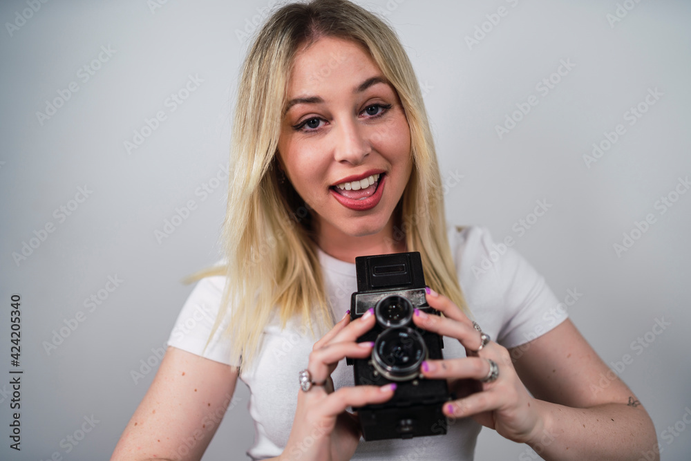 Chica rubia guapa muy sonriente con una camara de fotos antigua Chica rubia guapa muy sonriente con una camara de fotos antigua