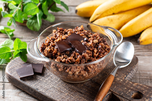 Chocolate oatmeal or oat porridge with chocolate on top served in small bowl. Selective Focus