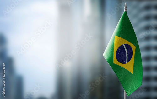 A small flag of Brazil on the background of a blurred background