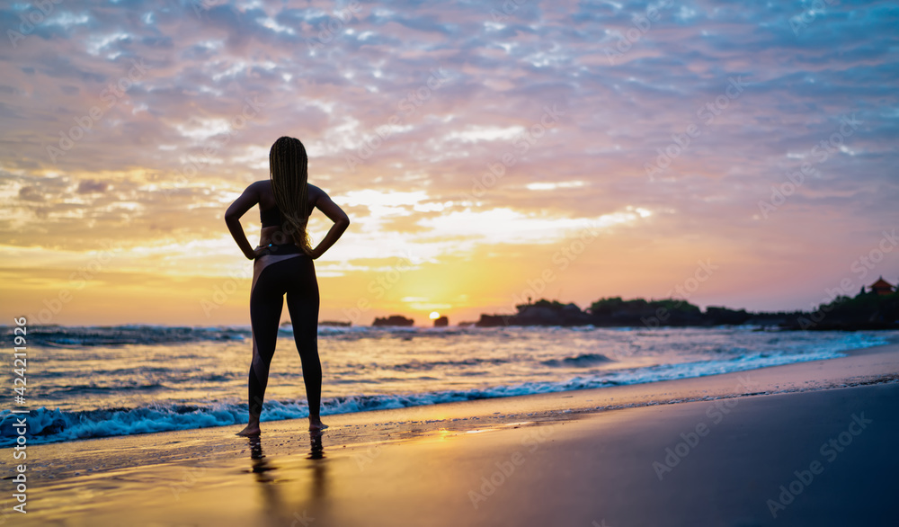 Back view of athletic trainer looking at picturesque colorful sky and seascape enjoying evening sunset at coastline, tranquil yogi in sportive wear getting energy and motivation from beautiful nature Back view of athletic trainer looking at picturesque colorful sky and seascape enjoying evening sunset at coastline, tranquil yogi in sportive wear getting energy and motivation from beautiful nature