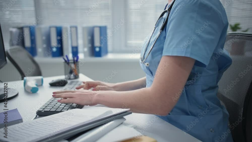 girl doctor is typing on computer keyboard while sitting at table and then feels a sharp pain in the lower back, female therapist does a stretch girl doctor is typing on computer keyboard while sitting at table and then feels a sharp pain in the lower back, female therapist does a stretch