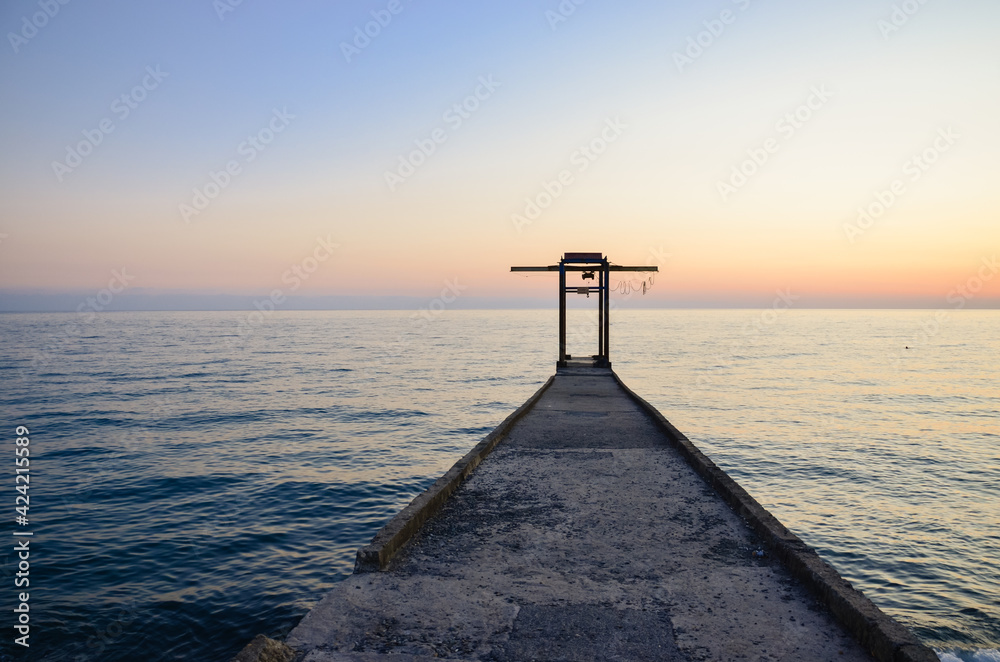 Sunset on the Black Sea. Pier and breakwater at sea.