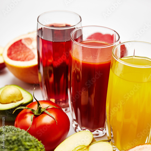 freshly squeezed fruit juice in glass glasses with a composition of fruit on a light background