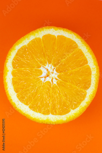 Orange fruit on orange background. Minimalism, original beautiful photo.