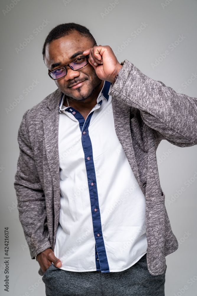 Handsome African American man in white shirt standing against grey background. Closeup. Handsome African American man in white shirt standing against grey background. Closeup.