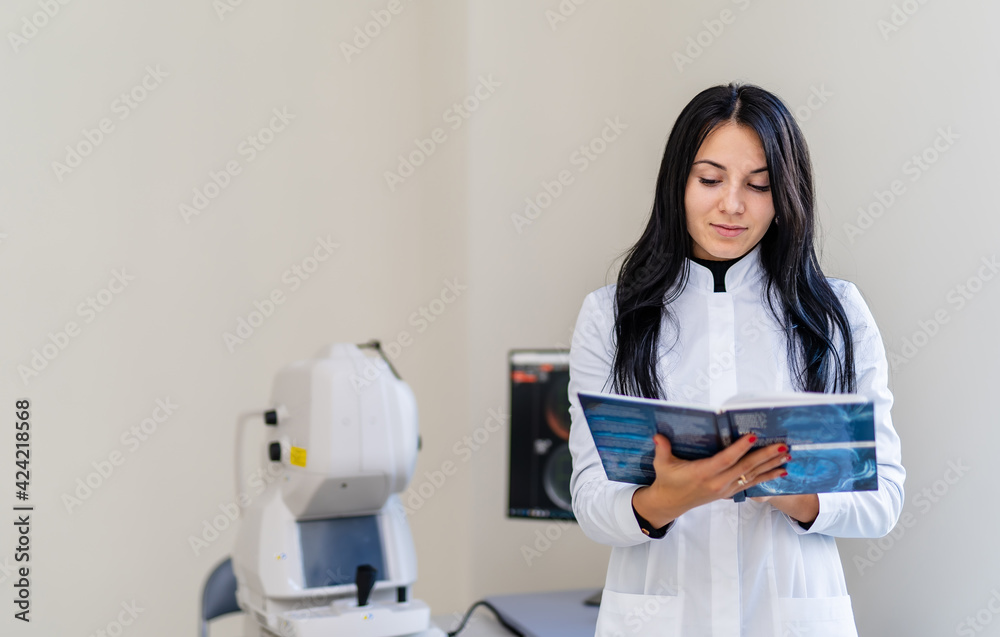 Young female doctor smiling happily posing at office near scanning machine. Medical industry technology. Modern equipment in clinic. Young female doctor smiling happily posing at office near scanning machine. Medical industry technology. Modern equipment in clinic.