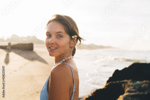 Optimistic lady standing near waving ocean