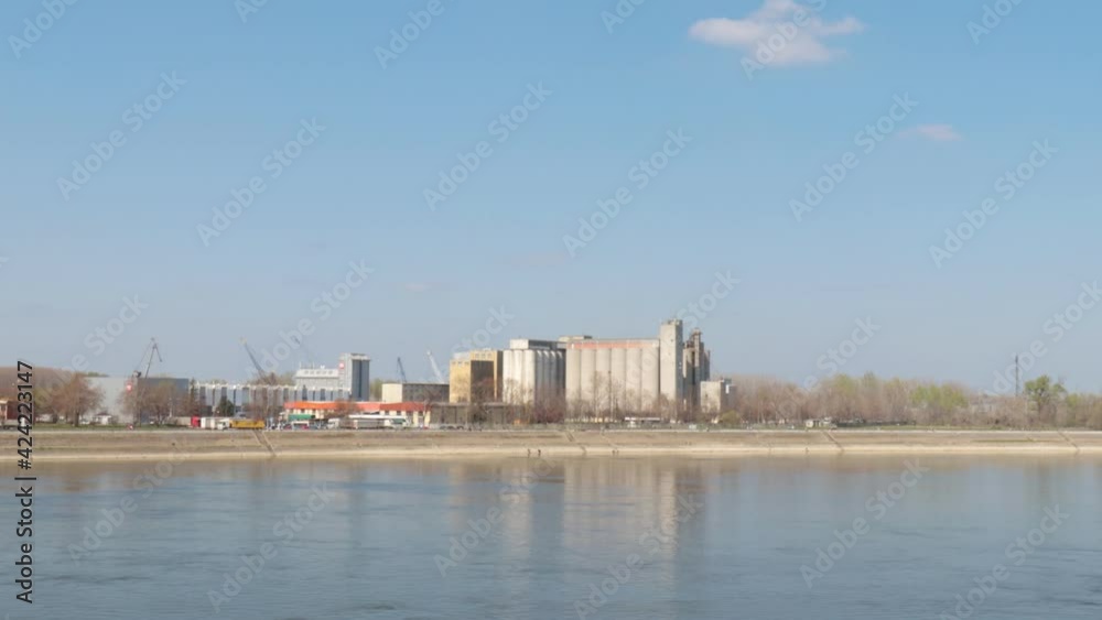 Large agricultural silos or grain tank for wheat and cereals near the river for easier transport selective focus Large agricultural silos or grain tank for wheat and cereals near the river for easier transport selective focus
