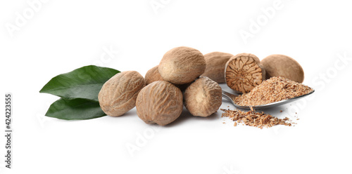 Grated nutmeg and seeds with green leaves on white background