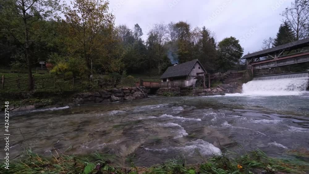 A dam and a beautiful old water mill, called Katzensteinermühle by the fast flowing Gaflenz River in Weyer, Steyr-Land, Upper Austria. Tourism in the mountains of the Alps. Panning from left to right. A dam and a beautiful old water mill, called Katzensteinermühle by the fast flowing Gaflenz River in Weyer, Steyr-Land, Upper Austria. Tourism in the mountains of the Alps. Panning from left to right.