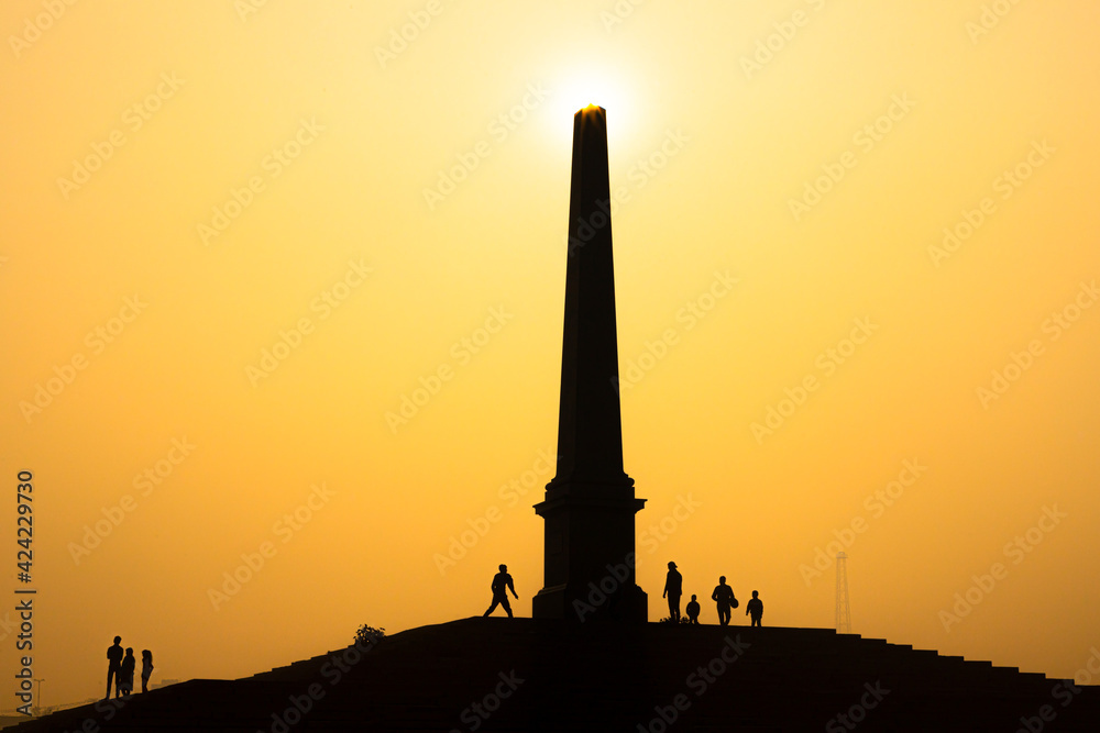 a beautiful silhouette view of sunrise and an ancient pillar in delhi.