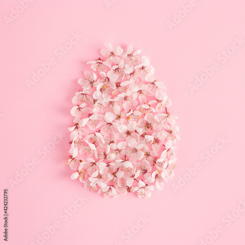 Creative Easter egg composition with spring flowers and rose background. Natural koncept. Flat lay.