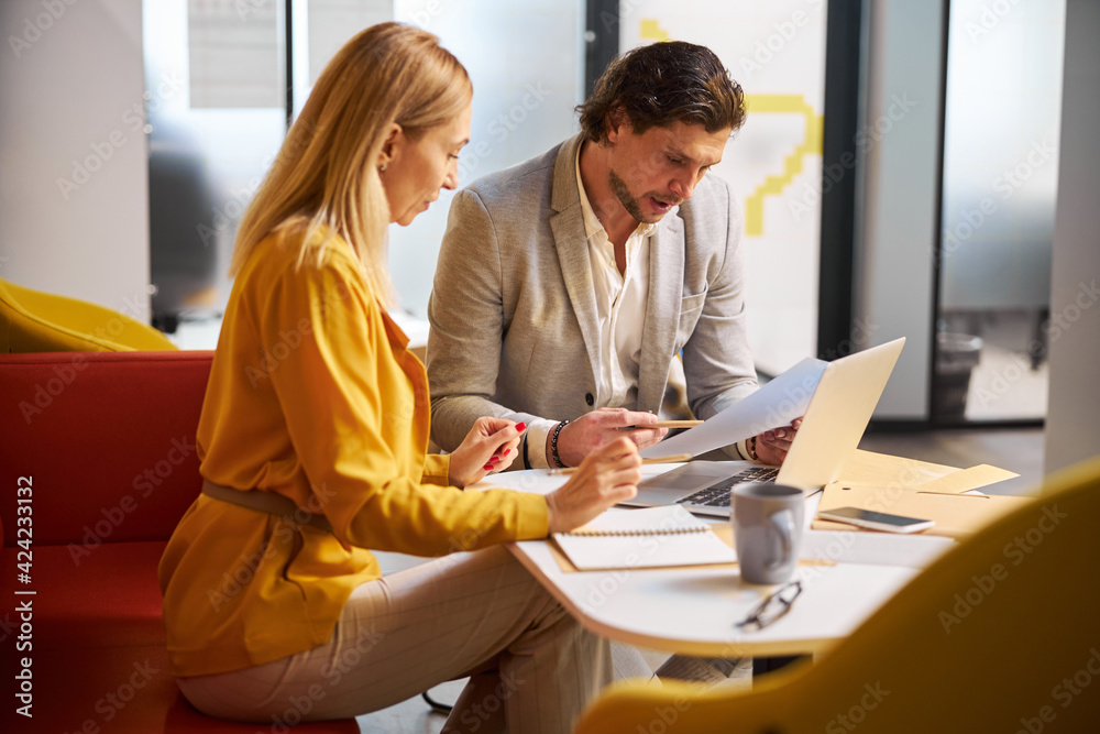 Fototapeta premium Concentrated young female person looking her notes