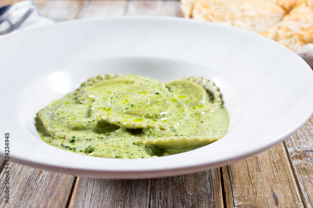 A view of a plate of pesto ravioli. A view of a plate of pesto ravioli.