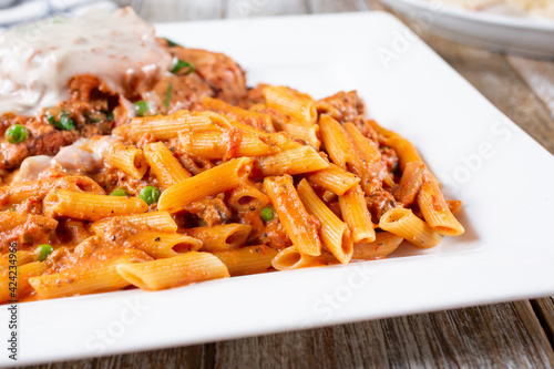 A view of penne pasta and chicken parmigiana.