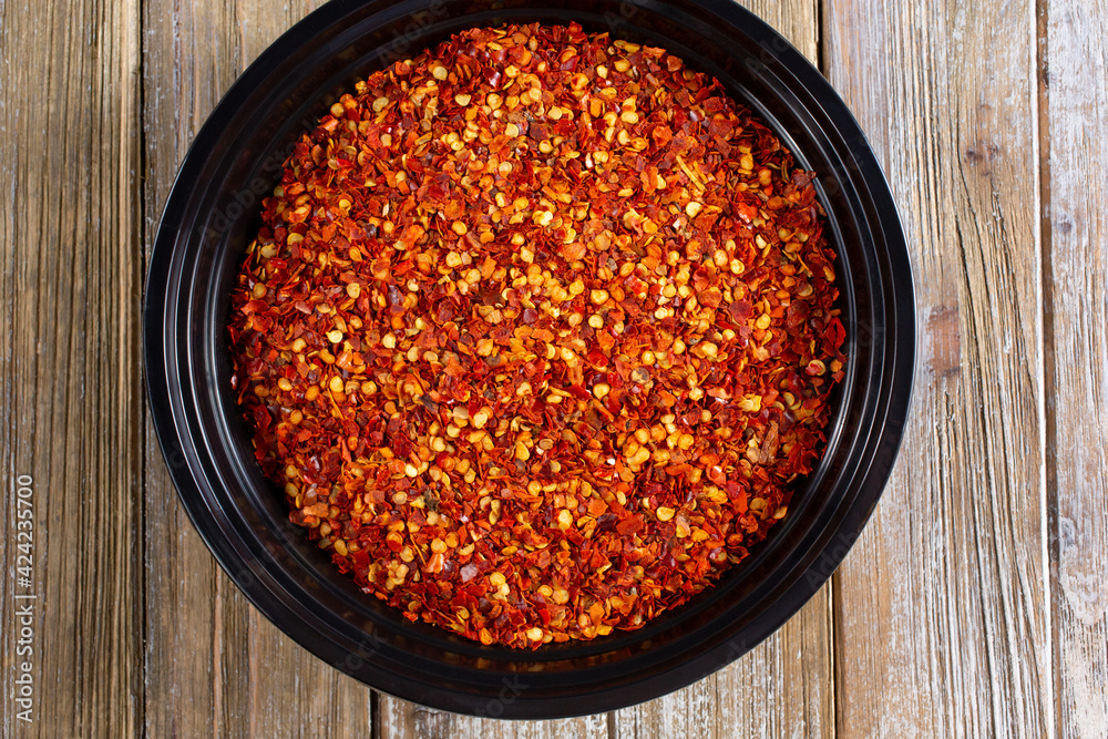 A top down view of a bowl of crushed red pepper flakes.