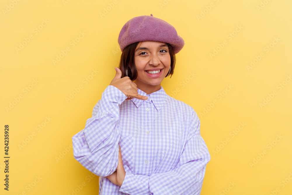 Young mixed race woman wearing a beret isolated on yellow background showing a mobile phone call gesture with fingers. Young mixed race woman wearing a beret isolated on yellow background showing a mobile phone call gesture with fingers.