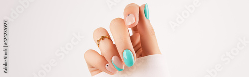 Womans hand with trendy turquoise manicure with copy space