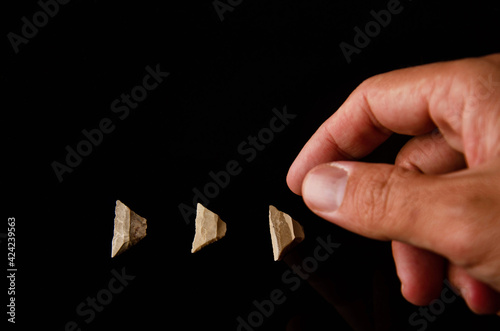 Prehistoric stones. Three microliths on a black background. Stone age. paleolithic. made of silex material photo