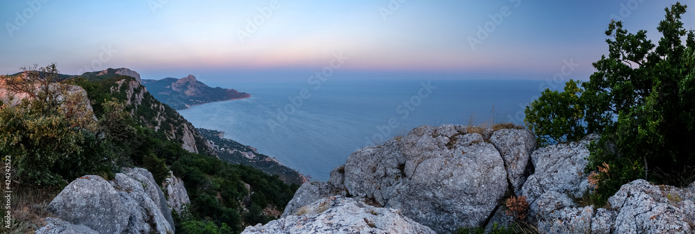 Obraz premium Mediterranean landscape. Forested rocks of the Black Sea coast of the southern coast of the Crimean peninsula at sunset.